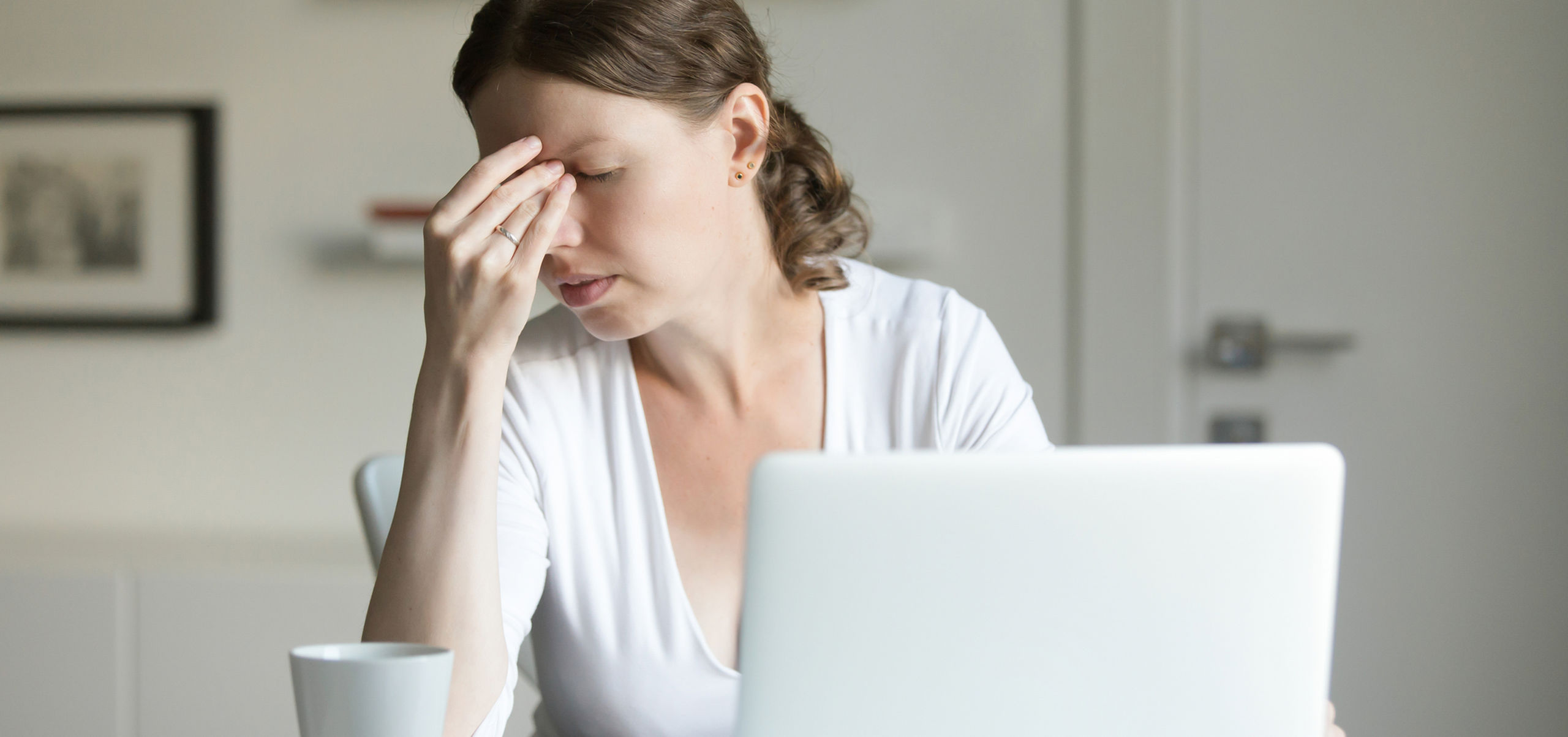 Portrait woman desk with laptop hand forehead